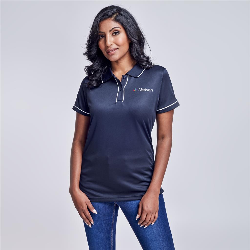 Female model wearing a navy branded polo shirt.