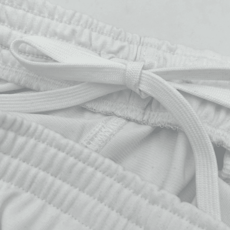 Close-up of white sports shorts waistband and drawstring.