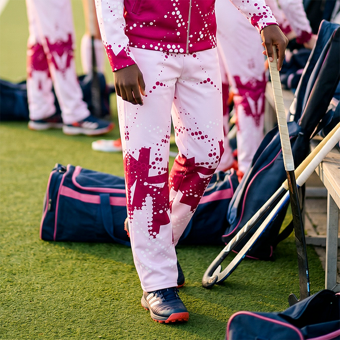 Athletes wearing pink and white team tracksuits.