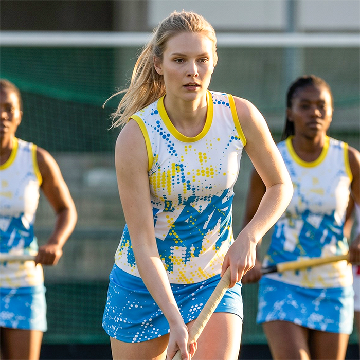 Female athlete wearing a blue and yellow netball dress.