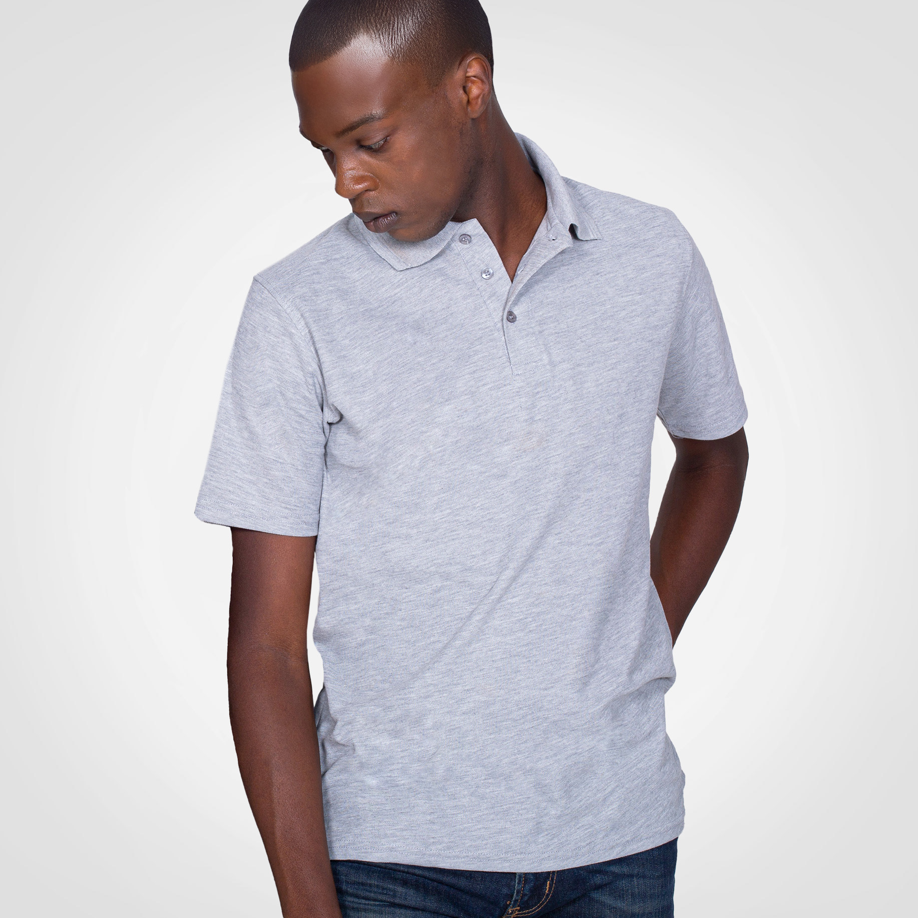 Male model wearing a light grey branded polo shirt.