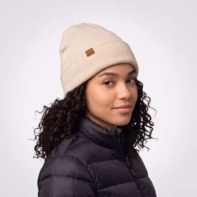 Female model wearing a cream Mainline Sportswear beanie.