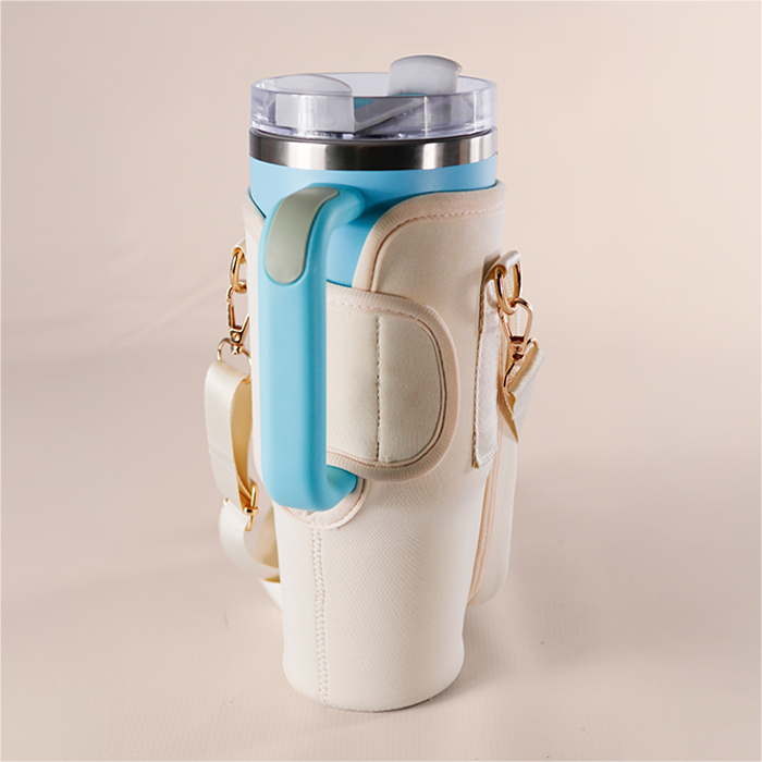 Nude bottle carrier holding an aqua insulated tumbler.