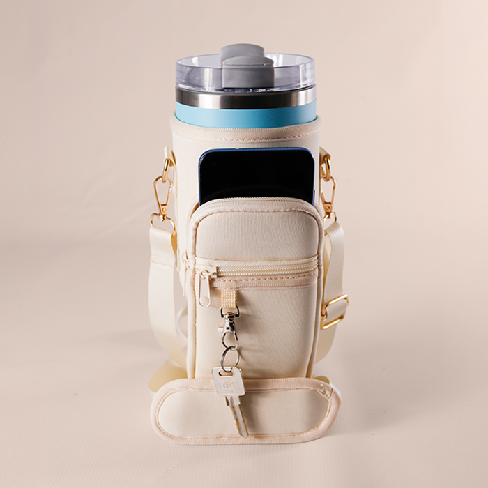 Nude bottle carrier holding a black insulated tumbler.